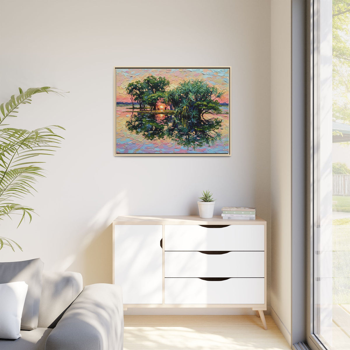 A colorful framed painting of trees reflected in water, hung on a light beige wall above a white wooden dresser in a modern, sunlit room.