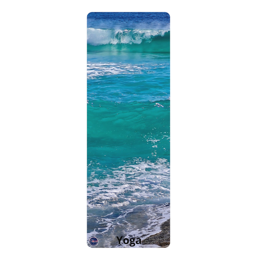 A tall yoga mat featuring a photographic print of turquoise ocean waves with white foam and a small 'Yoga' text print at the bottom, shown on a plain white background.
