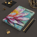 A hardcover journal featuring a colorful, textured impasto-style painting of a lotus flower.
