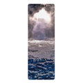 A tall yoga mat featuring a photographic print of ocean waves under a dramatic cloudy sky with bright sunlight breaking through, on a plain white background.